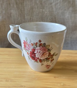 Kopp med roser og blomst på hanken